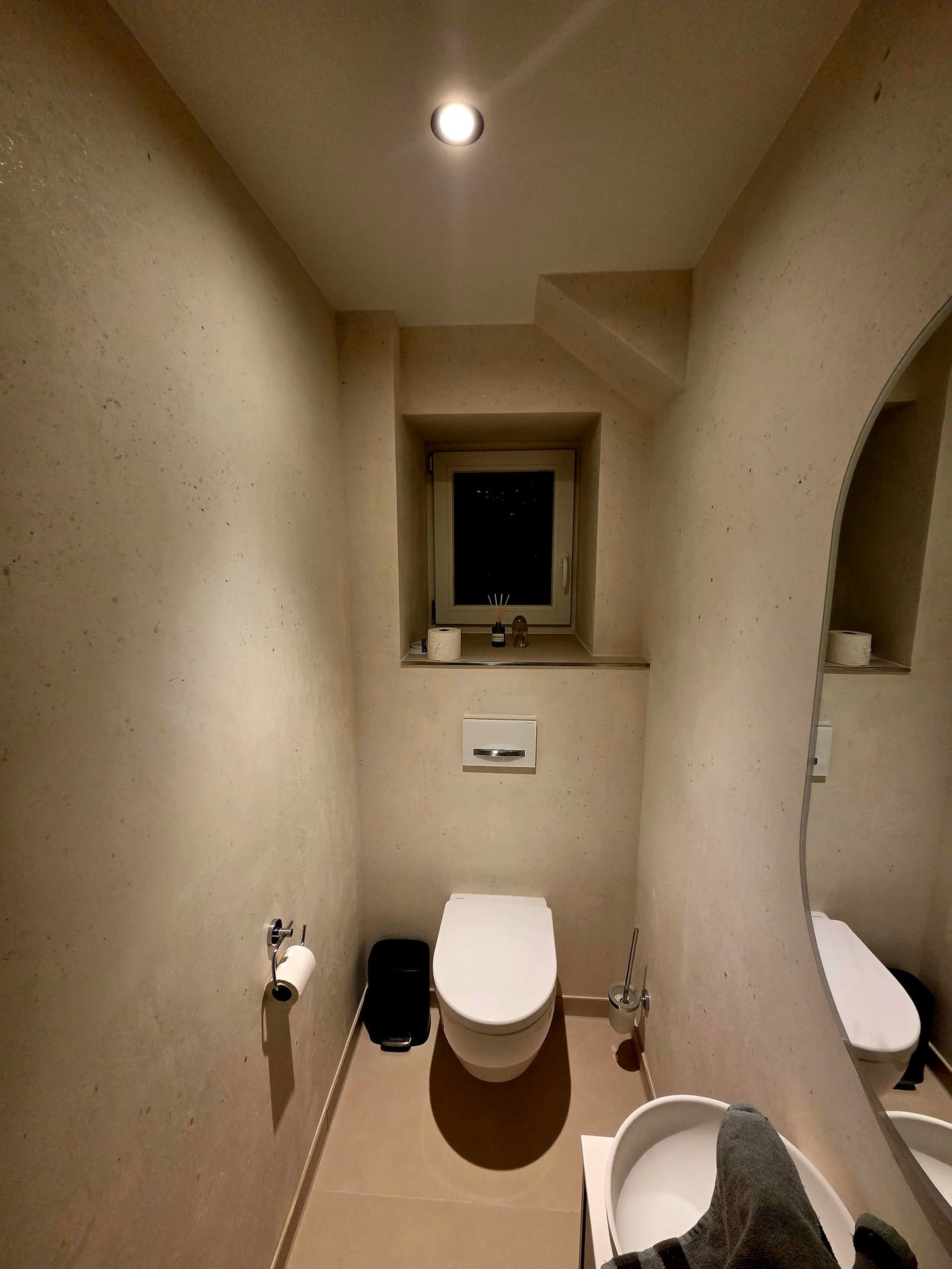 Gäste-WC mit Wänden in Kalk-Marmor, Nische mit Fenster und Rundbogen
