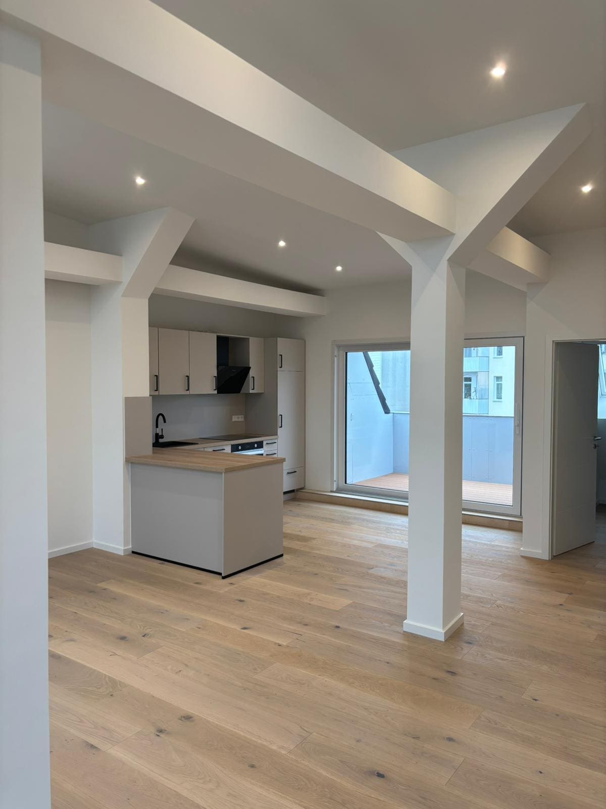 Helle Loft-Wohnung mit weißen Balken und Holzboden